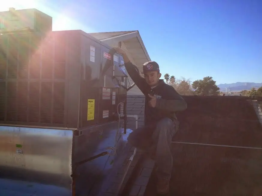 HVAC technician performing Air Duct Cleaning on a rooftop unit in St. Charles